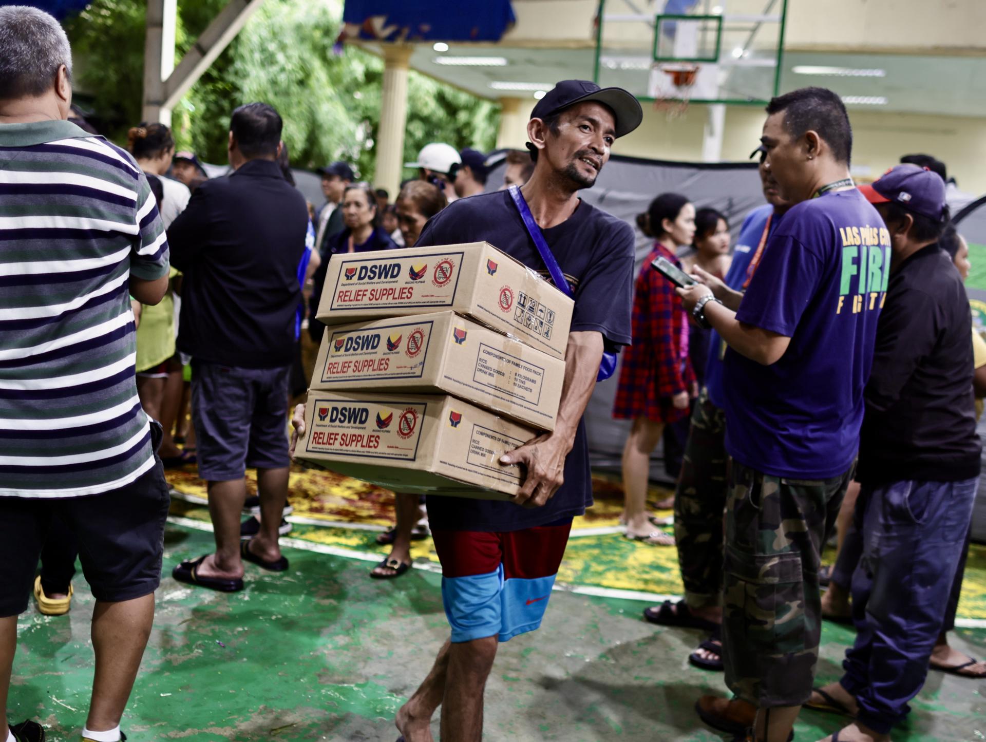 Filipinos reciben ayuda de emergencia tras el azote de la tormenta Wipha, que causó inundaciones en Manila.
EFE/EPA/FRANCIS R. MALASIG