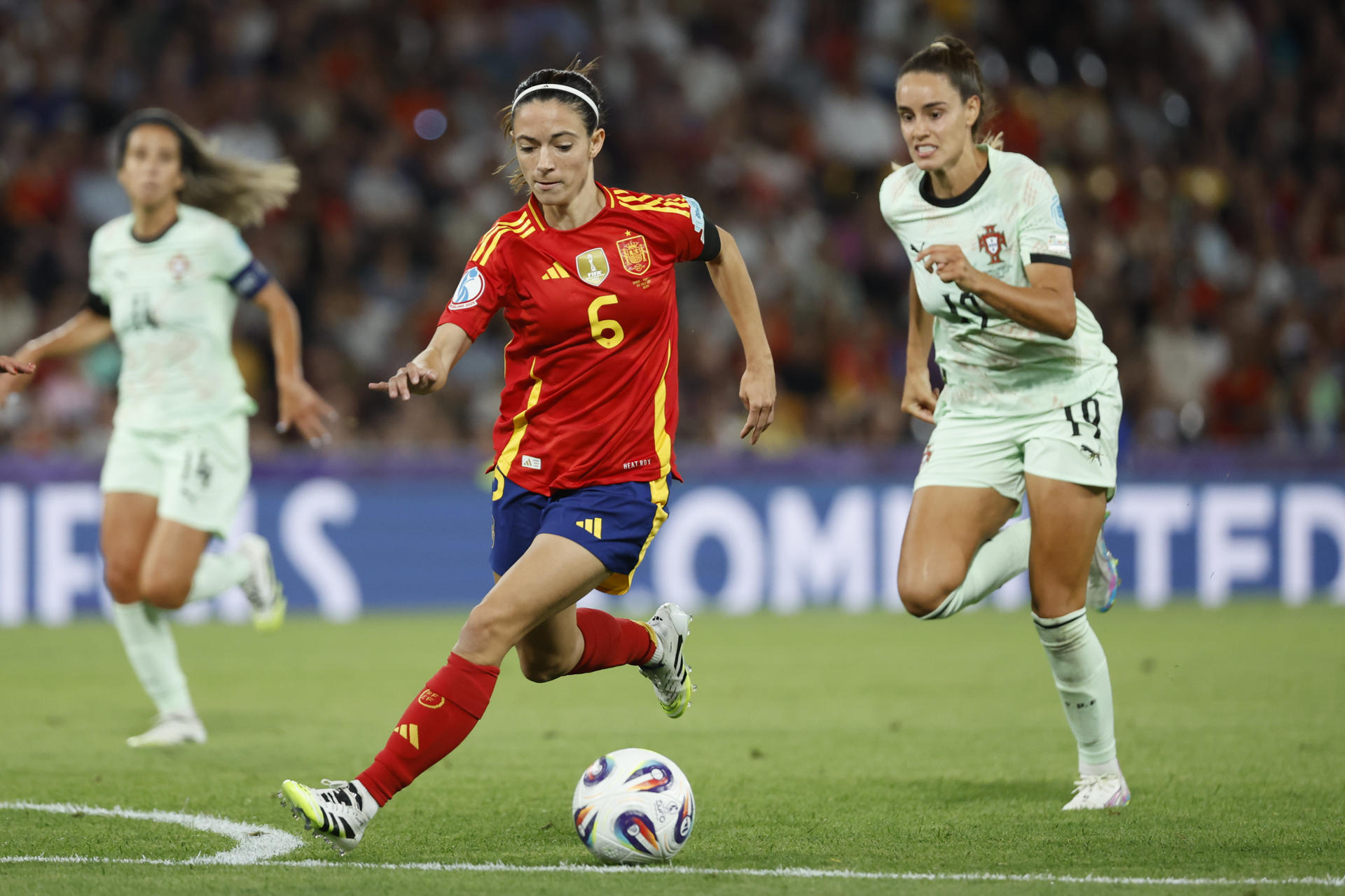 La centrocampista de la selección española, Aitana Bonmatí (i), se lleva el balón ante la defensora de Portugal, Diana Gomes, durante el partido del grupo B de la Eurocopa Femenina 2025, disputado este jueves entre Portugal y España, en el Stade de Suisse en Berna. EFE/ Ana Escobar