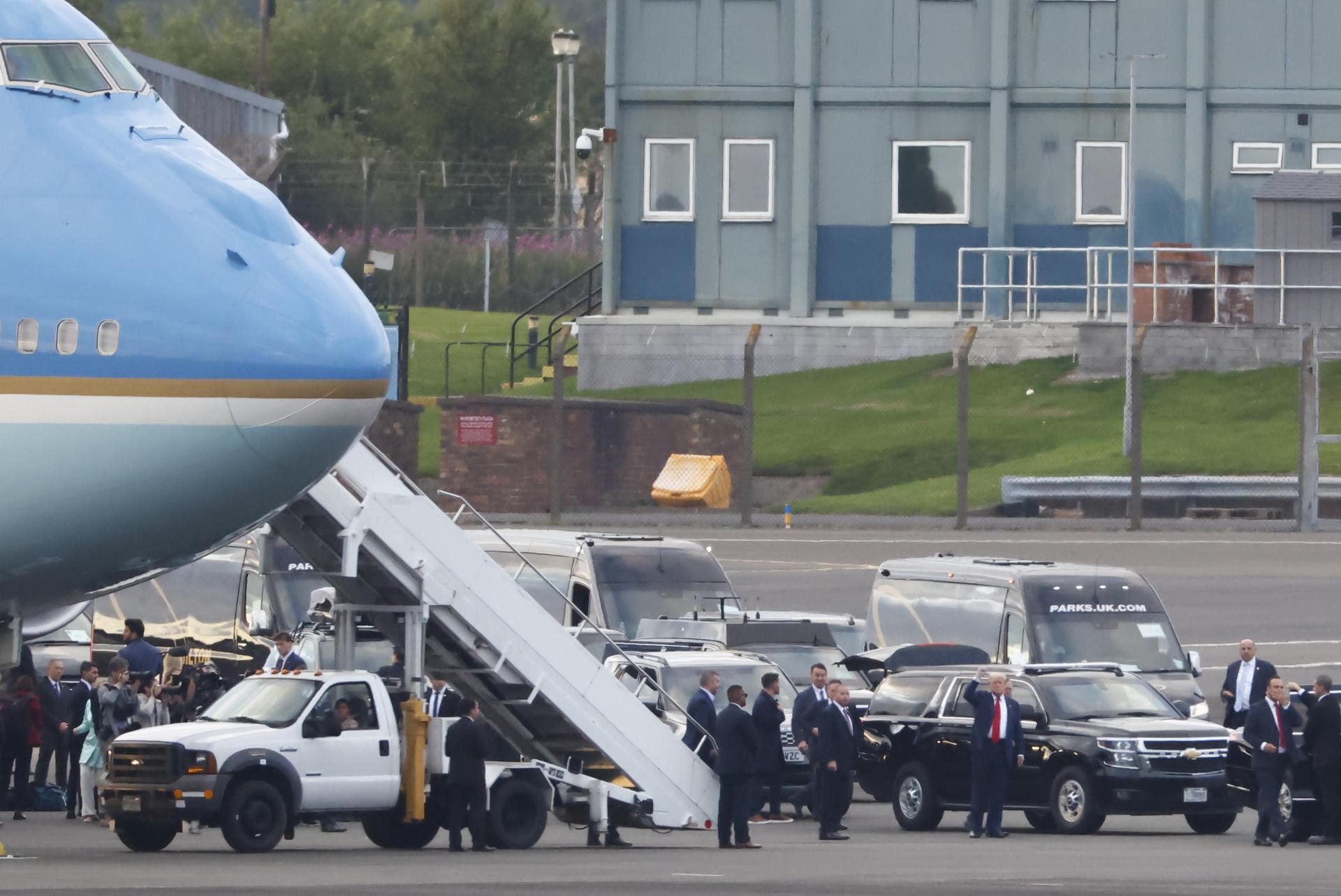 El presidente de Estados Unidos, Donald J. Trump (d), saluda a la multitud al aterrizar en el aeropuerto de Prestwick en Glasgow, Escocia, Gran Bretaña, el 25 de julio de 2025. EFE/EPA/TOLGA AKMEN
