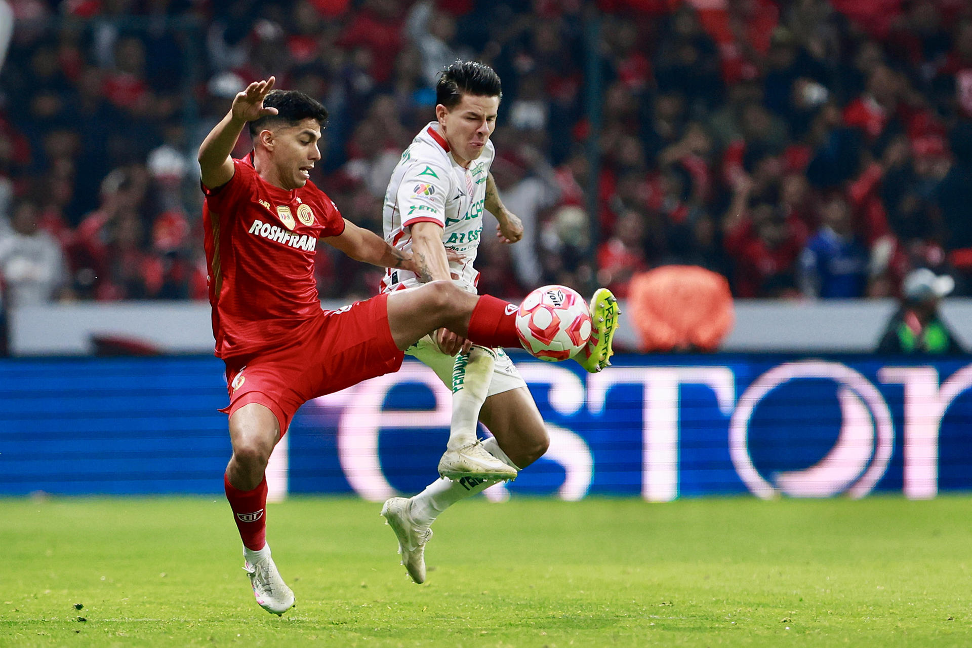 Diego Barbosa (i), de Toluca, disputa un balón con Pavel Pérez (d), de Necaxa, durante un partido de la Liga MX entre Toluca y Necaxa en el estadio Nemesio Diez en Toluca (México). EFE/Felipe Gutiérrez