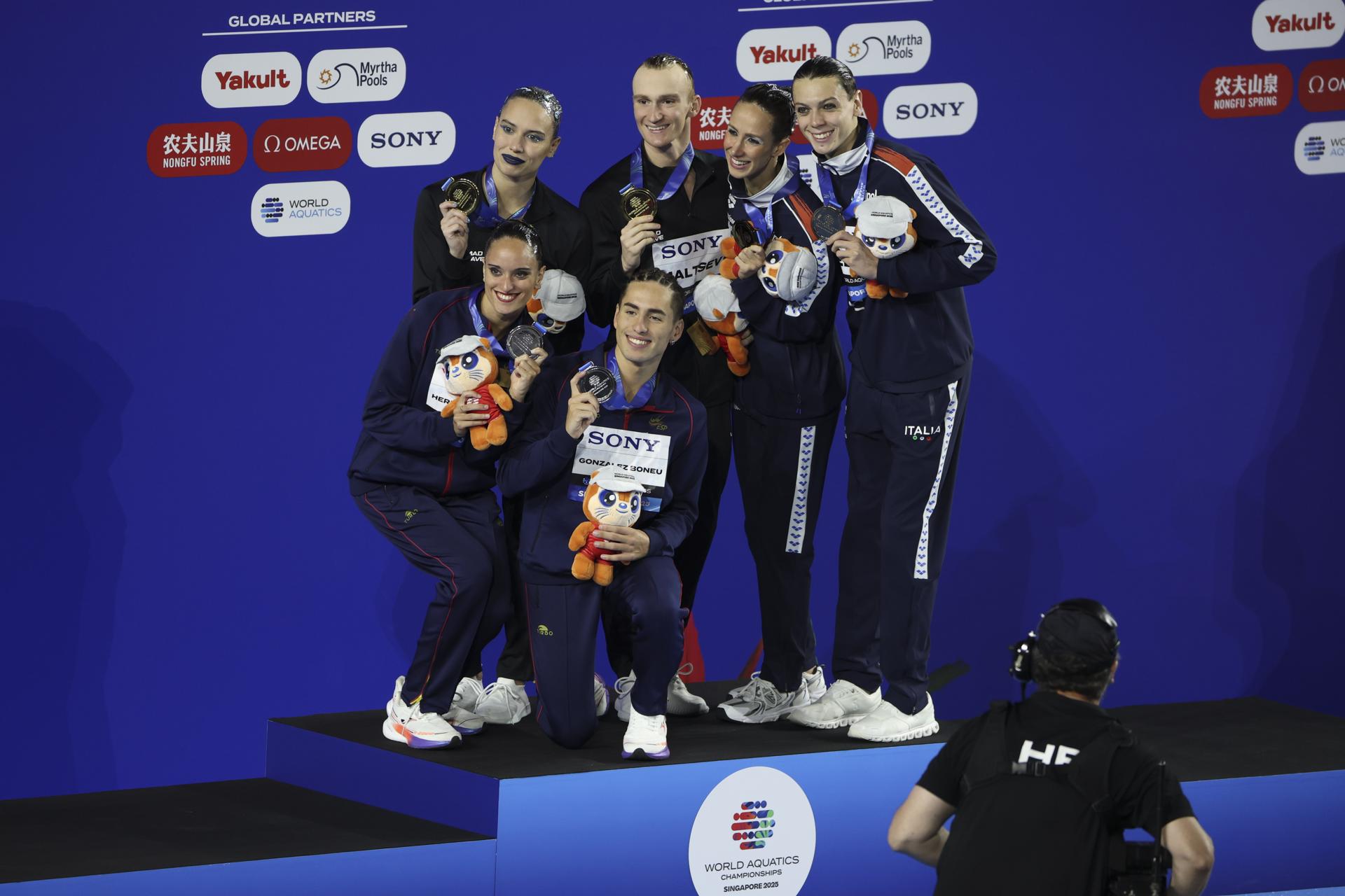 Los españoles Dennis González y Mireia Hernández (iz) celebran en el podio la plata en rutina técnica del dúo mixto. El oro fue para los rusos Mayya Gurbanberdieva y Aleksandr Maltsev y el bronce para los italianos Lucrezia Ruggiero y Filippo Pelati. EFE/EPA/FAZRY ISMAIL