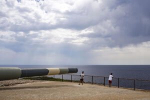 Turistas observan este miércoles la llegada de nubes de lluvia desde la Fortaleza de Isabel II en La Mola, Menorca. EFE/David Arquimbau Sintes