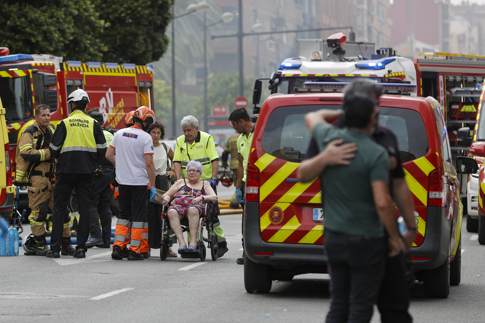 Varios bomberos trabajan en la extinción del fuego de un comercio situado en un edificio de viviendas de la Avenida del Puerto de València. EFE/Manuel Bruque