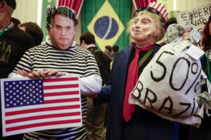 Personas con máscaras del presidente de Estados Unidos, Donald Trump, y del expresidente de Brasil Jair Bolsonaro asisten al lanzamiento de un manifiesto en defensa de la soberanía nacional este viernes, en São Paulo (Brasil). EFE/ Sebastiao Moreira