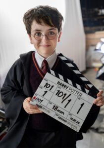 Fotografía cedida por HBO donde aparece Dominic McLaughlin caracterizado como Harry Potter, sosteniendo la claqueta de la serie. EFE/Aidan Monaghan/HBO