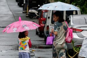 CIUDAD QUEZÓN (Filipinas), 03/07/2025.- Una madre camina con su hija frente a una escuela primaria pública tras la suspensión de clases en Ciudad Quezón, Metro Manila, Filipinas, el 3 de julio de 2025, debido a las fuertes lluvias asociadas a la depresión tropical Bising, que se espera produzca inundaciones y deslizamientos de tierra mientras toma fuerza y se desplaza hacia el mar al sur de Taiwán. EFE/EPA/ROLEX DELA PENA