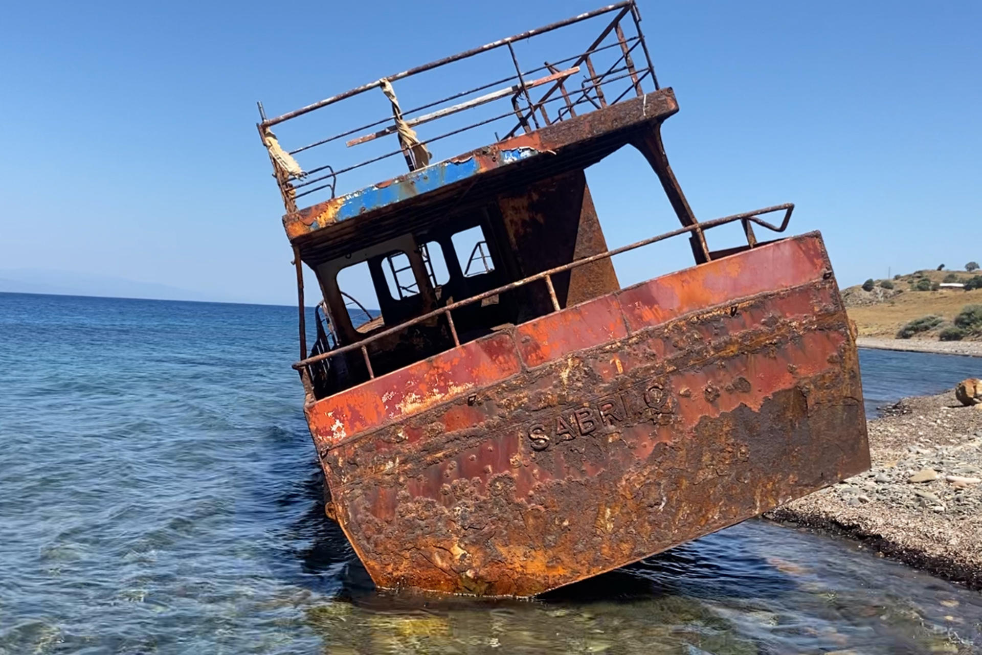 Vista este sábado de un barco, el "SABRI. Ç", que encalló en una playa de la isla griega de Lesbos mientras trasladaba a inmigrantes desde las cercanas costas turcas en 2015, año en el que más de medio millón de refugiados e inmigrantes llegaron a esta isla de unos 80.000 habitantes. EFE/ Diego Sáez Papachristou