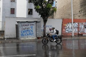 Una persona en motocicleta pasa frente a un grafiti de la alcaldesa del municipio Libertador de Caracas, Carmen Melénez, este sábado en Caracas (Venezuela). EFE/ Ronald Peña R