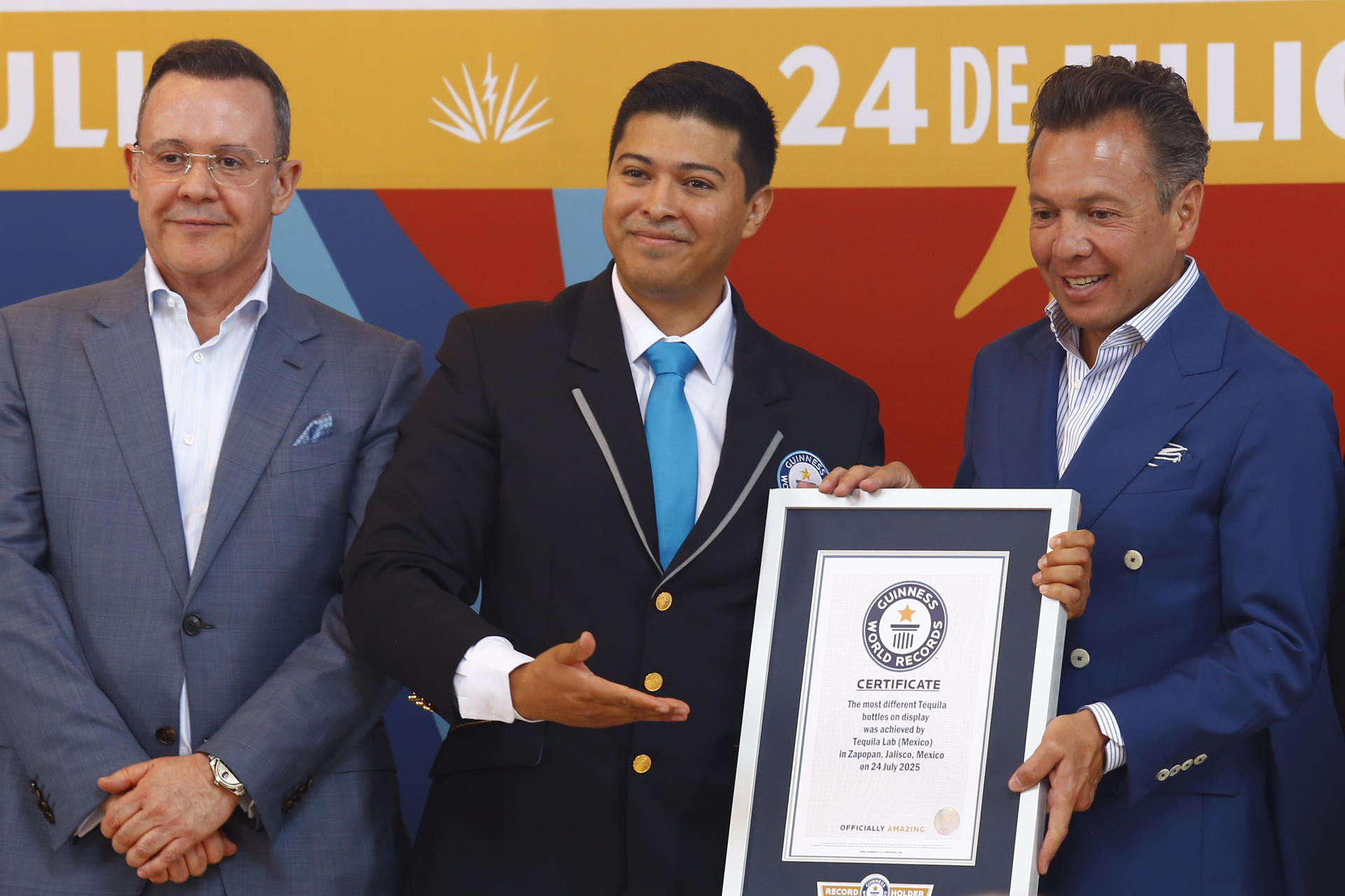 El presidente de la Cámara Nacional de la Industria Tequilera; Roberto Ciprés Cruces (i), el adjudicador oficial de Guinness World Records, Carlos Tapia Rojas (c) y el gobernador de Jalisco, Pablo Lemus (d) posan con el Record Guinnes este jueves, en TequilaLab en la ciudad de Guadalajara, estado de Jalisco (México). EFE/ Francisco Guasco