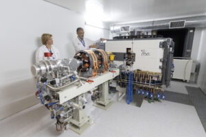 El director clínico de Radiología y Medicina Nuclear de Vall Hebron, Manel Escobar, y la jefe del Servicio de Medicina Nuclear de Vall d'Hebron, Cristina Gámez, junto al acelerador de partículas denominado ciclotrón, que este lunes ha instalado el Institut de Recerca del Hospital Universitario Vall d'Hebron (VHIR) de Barcelona, para producir radiofármacos usados en el diagnostico y tratamiento de diversas patologías, en especial, las cancerígenas, cardíacas y neurológicas. EFE/Marta Pérez