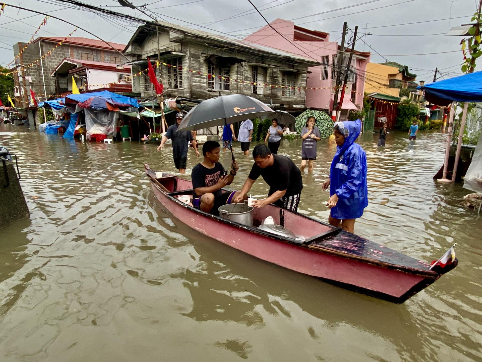 KAWIT (Philippines), 24/07/2025.- People wade through floodwater at the flood-hit town of Kawit, Cavite province, south of Manila, Philippines, 24 July 2025. The Philippines weather bureau projected typhoon Co-May to be 210 kilometers west of Pangasinan province in the northern Philippines, with winds of 120 kilometers per hour near its center. (Filipinas) EFE/EPA/FRANCIS R. MALASIG

