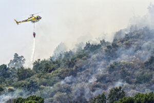 -Un helicóptero trabaja en las labores de extinción del incendio en Mombeltrán (Ávila). EFE/ Raúl Sanchidrián