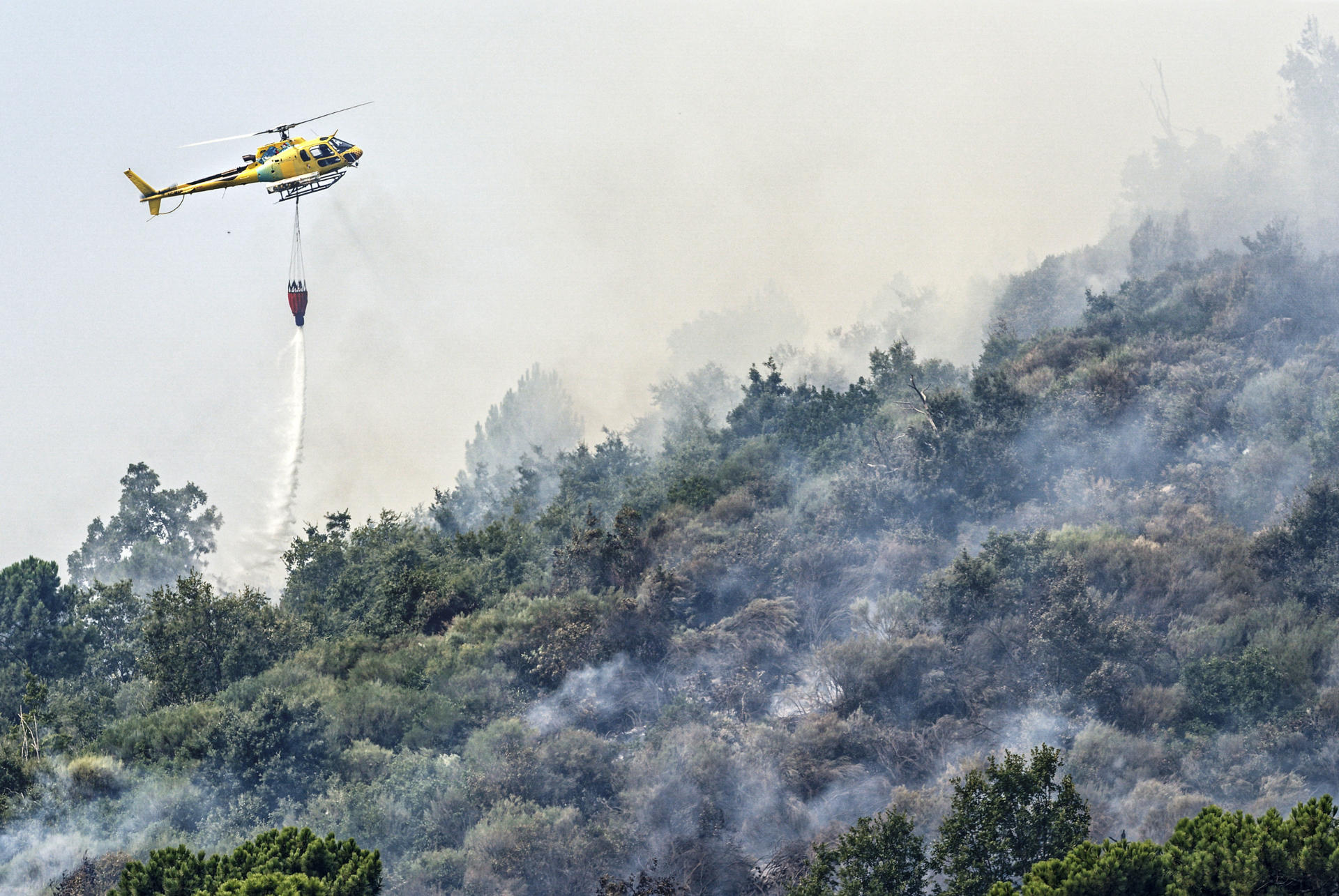 -Un helicóptero trabaja en las labores de extinción del incendio en Mombeltrán (Ávila). EFE/ Raúl Sanchidrián