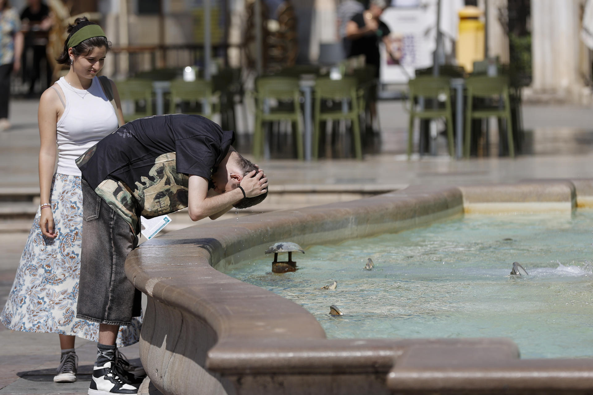Una persona se refresca en una fuente del centro de la ciudad de Valencia el pasado mes de junio. EFE/Manuel Bruque