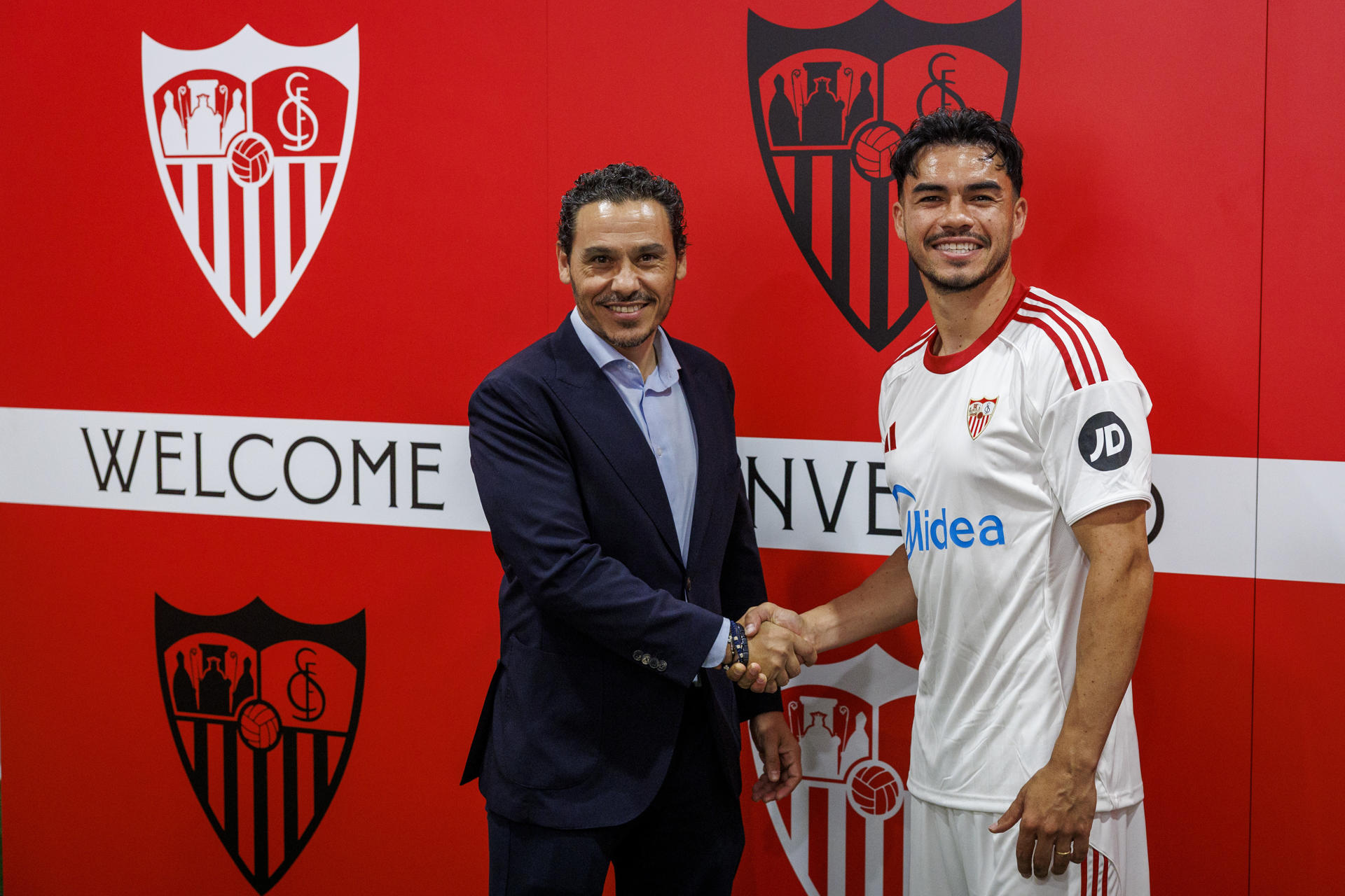 El presidente del Sevilla FC, José María del Nido Carrasco (i), estrecha la mano del defensor chileno Gabriel Suazo que llega como agente libre desde el Toulouse francés y ha firmado por tres años con el club sevillista, durante su presentación en el estadio Sánchez Pizjuán de la capital hispalense. EFE/ Julio Muñoz