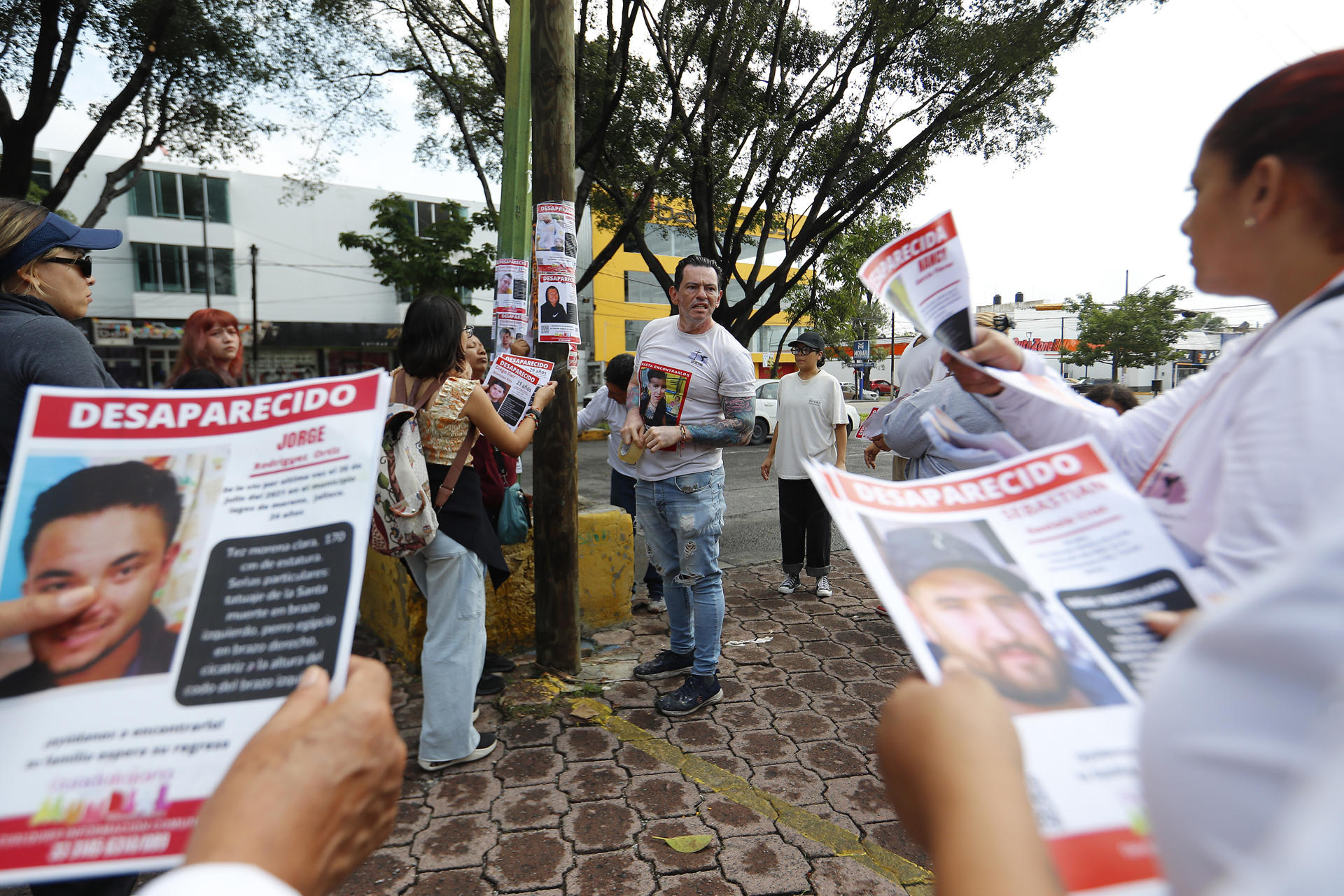 Integrantes de colectivos de búsqueda pegan carteles de personas desaparecidas este sábado, en Guadalajara (México). EFE/Francisco Guasco