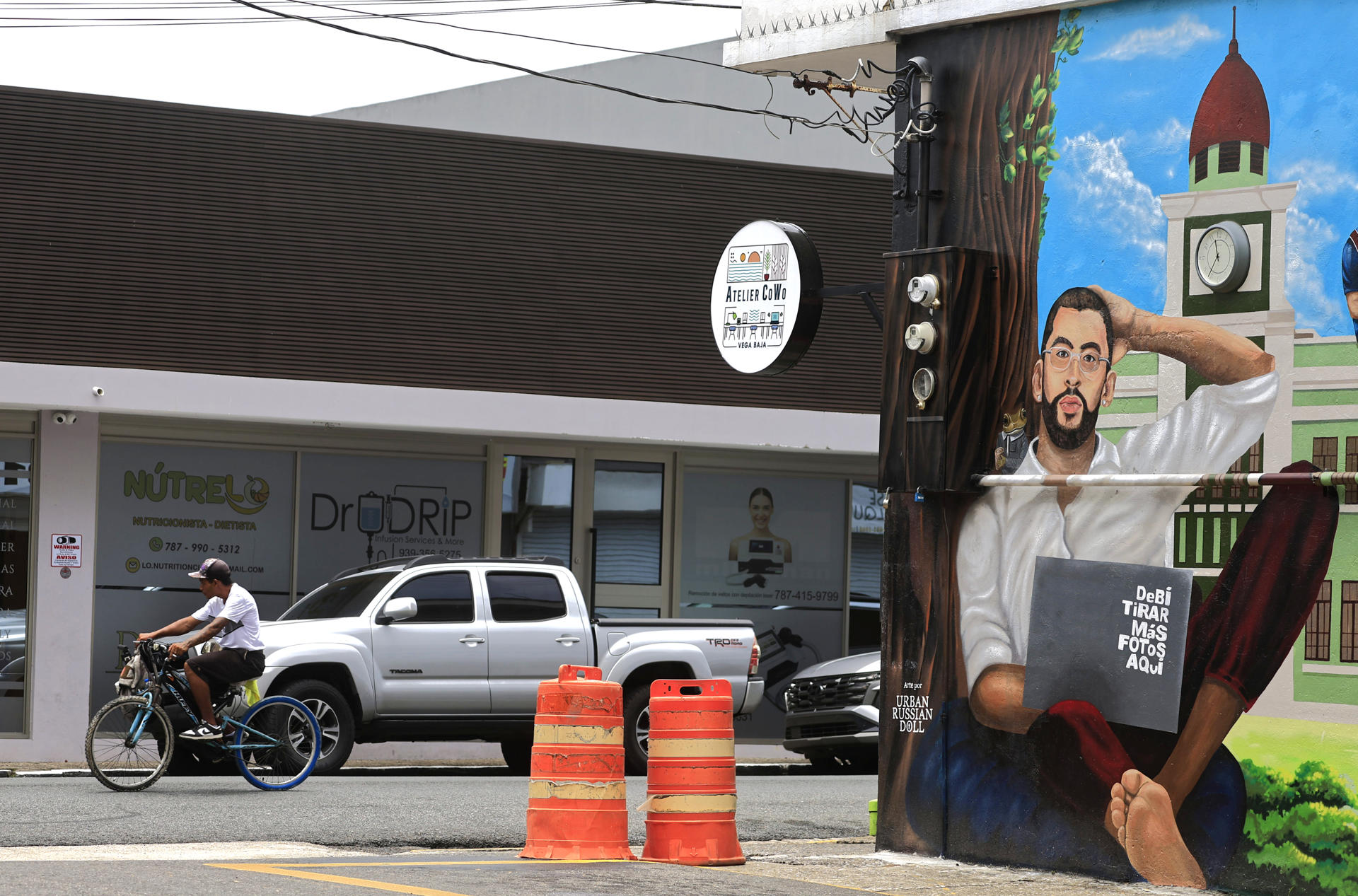 Una persona pasa en bicicleta frente a un mural de Bad Bunny, en Vega Baja (Puerto Rico). EFE/Thais Llorca