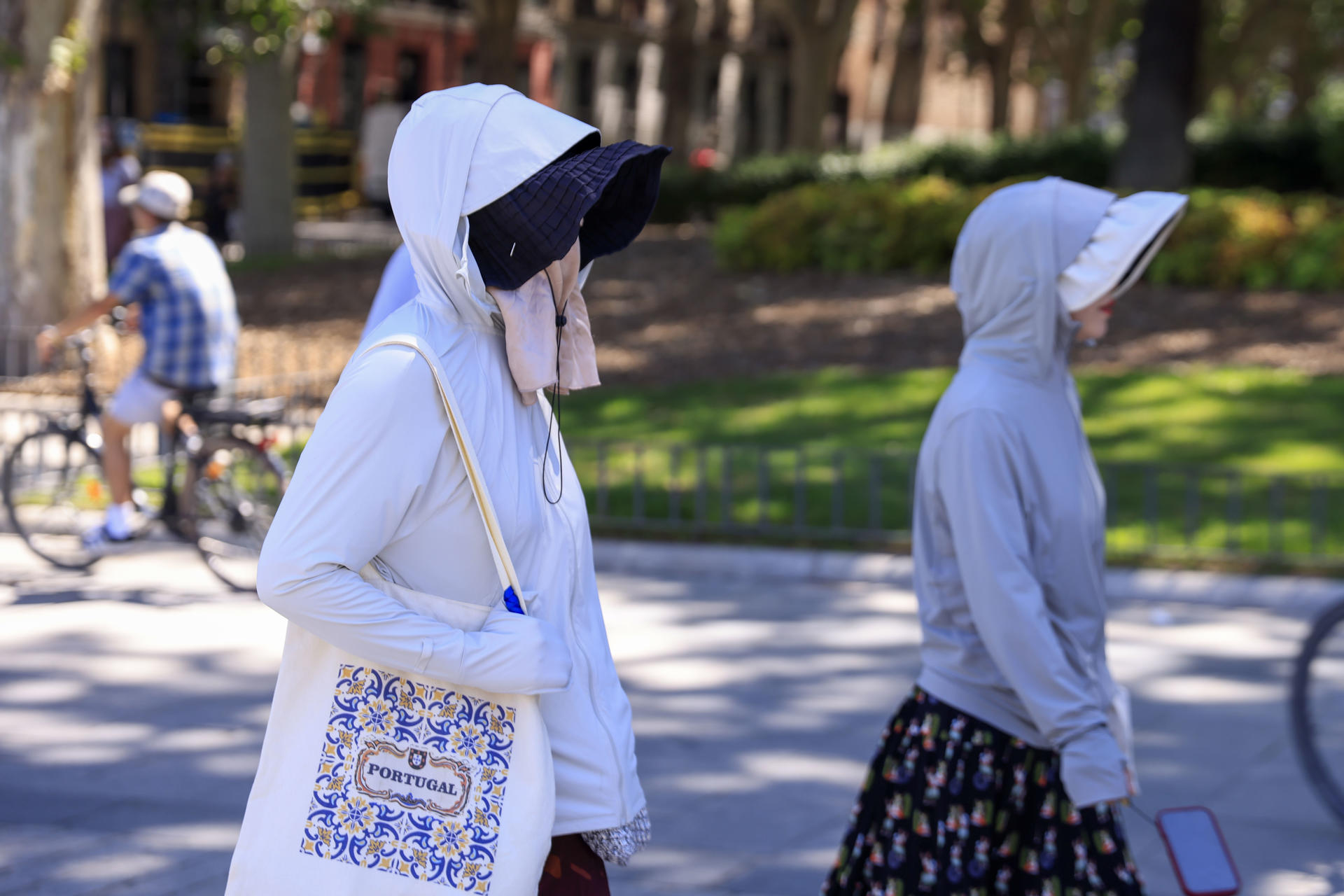 Dos turistas se protegen del sol en los alrededores del Palacio Real este martes en Madrid. El calor será intenso desde este martes en casi todo el territorio debido a la presencia de una masa de aire muy cálido que dará un alivio entre el viernes y el sábado, pero que repuntará el domingo, con temperaturas significativamente altas hoy en el centro y mitad sur peninsular así como en Canarias. EFE/ Pablo R. Seco