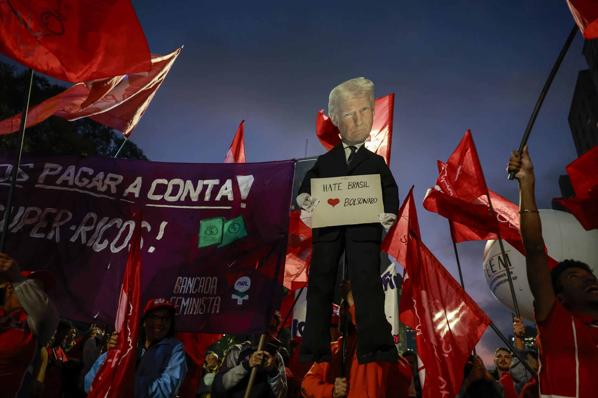 Integrantes de movimientos sociales sostienen un cartel con la imagen del presidente de Estados Unidos, Donald Trump, durante una manifestación en defensa del Gobierno de Luiz Inácio Lula da Silva este jueves, en Sao Paulo (Brasil). EFE/ Sebastiao Moreira