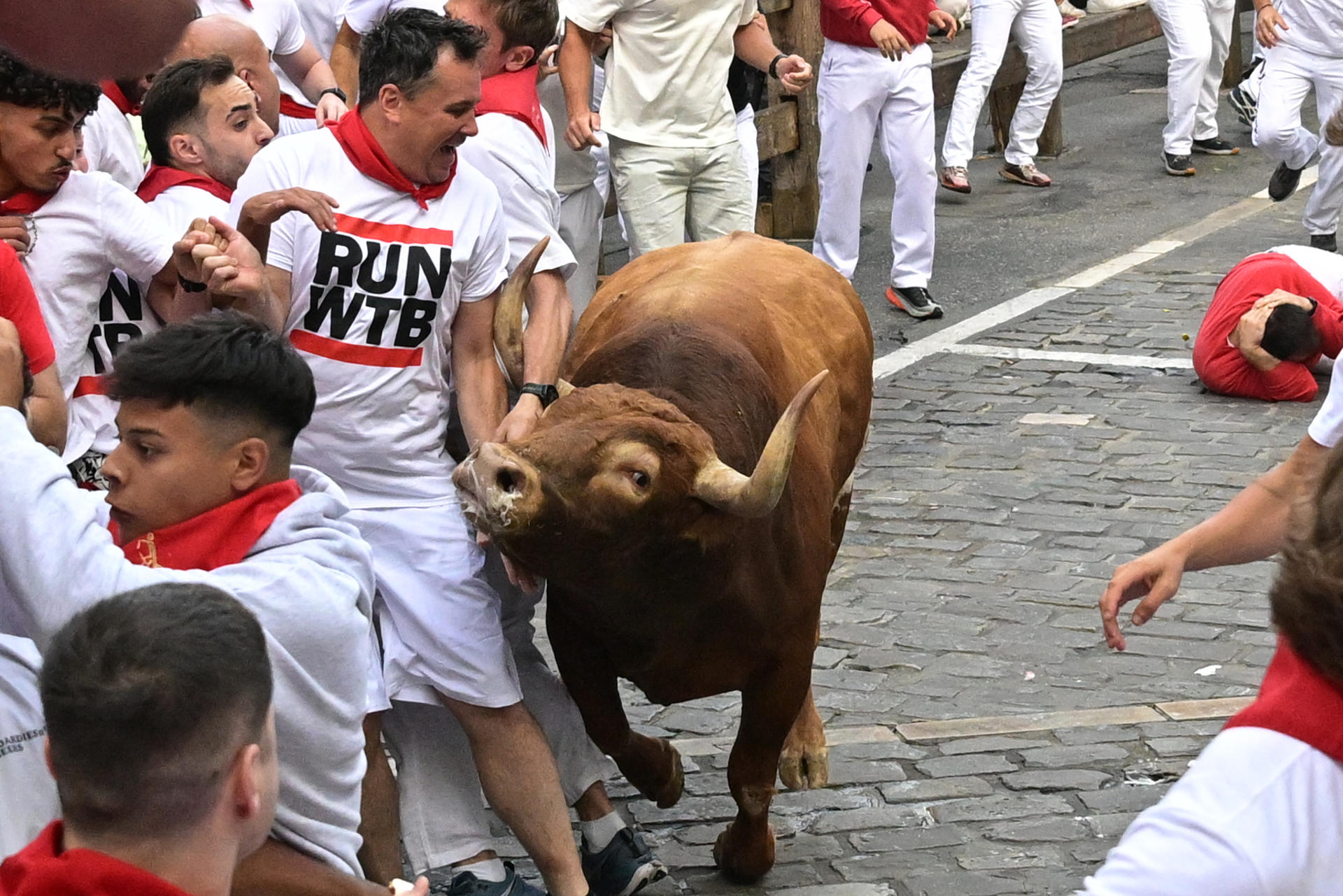 Un mozo evita a uno de los toros de la ganadería Jandilla durante el quinto encierro de los Sanfermines este viernes en Pamplona. EFE/Daniel Fernandez
