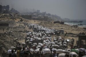 Palestinos desplazados internamente llevan bolsas de harina cerca de un punto de distribución de alimentos en Zikim, en la franja de Gaza norte, el 27 de julio de 2025. EFE/EPA/MOHAMMED SABER
