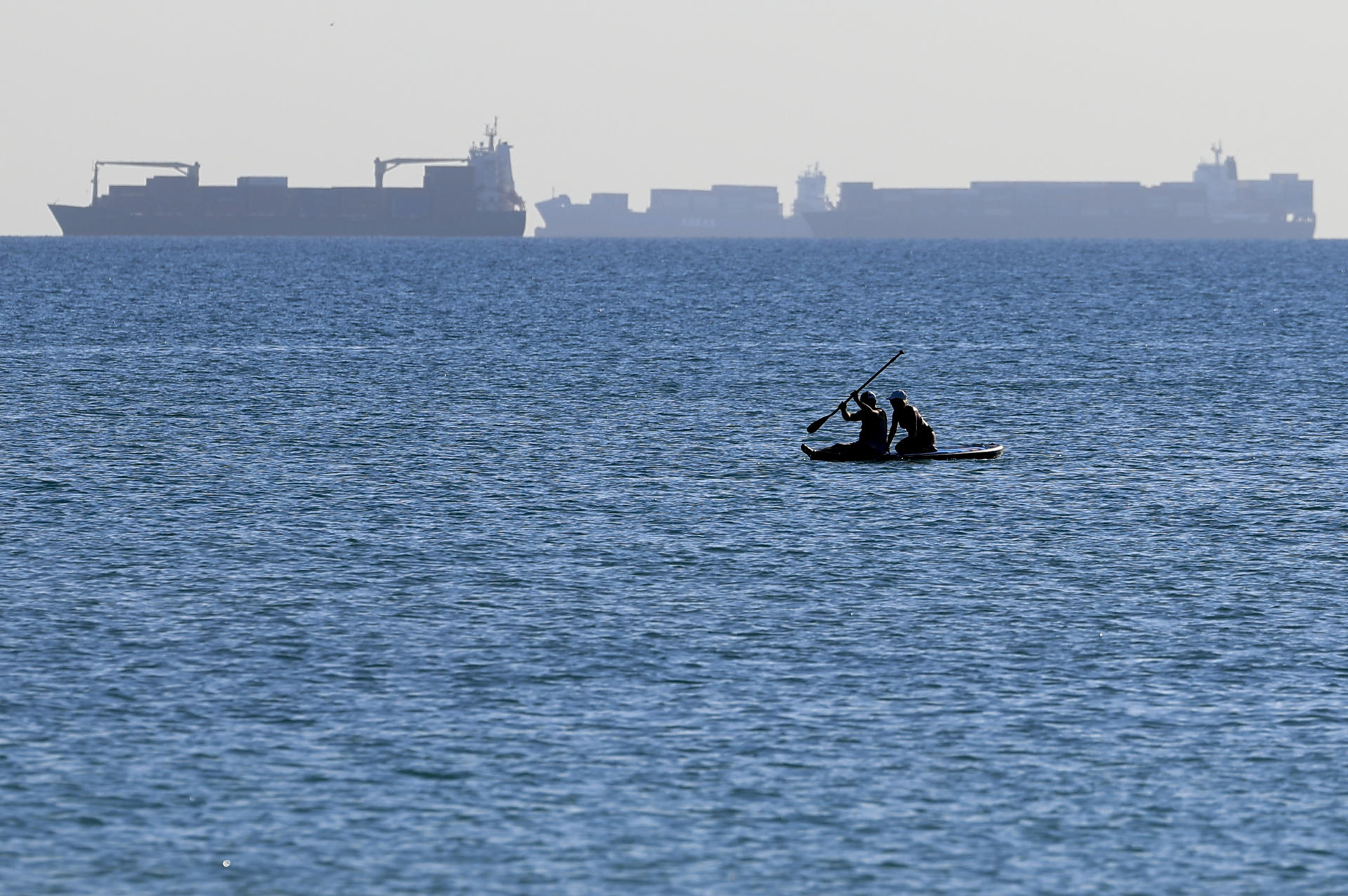 Dos personas disfrutan del paddle surf en aguas de la playa de El Saler, en Valencia, durante este lunes. EFE/Kai Försterling