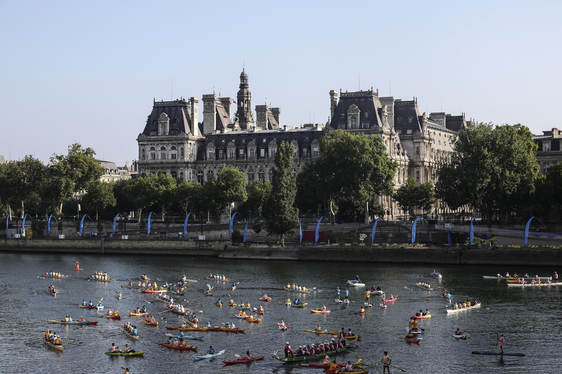 Participantes en el Festival del Sena pasan frente al Ayuntamiento de París mientras navegan en kayak, reman y practican paddle surf por el río como parte de las celebraciones del primer aniversario de los Juegos Olímpicos de París 2024. EFE/EPA/TERESA SUAREZ