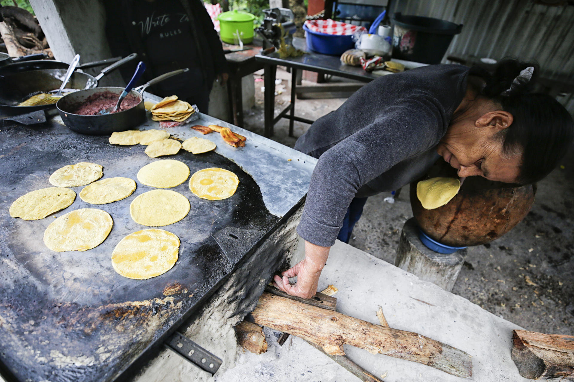 Una mujer prepara alimentos este martes en Santa Lucía (Honduras). EFE/ Gustavo Amador