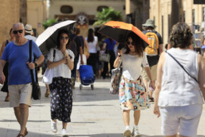 Dos mujeres se protegen del sol con paraguas este domingo en Valencia. La Agencia Estatal de Meteorología mantiene para hoy los avisos por probabilidad de chubascos y tormentas localmente fuertes en el interior de Valencia y Castellón, y se mantienen las temperaturas significativamente altas en el prelitoral de Valencia y del sur de Alicante. EFE/ Kai Forsterling