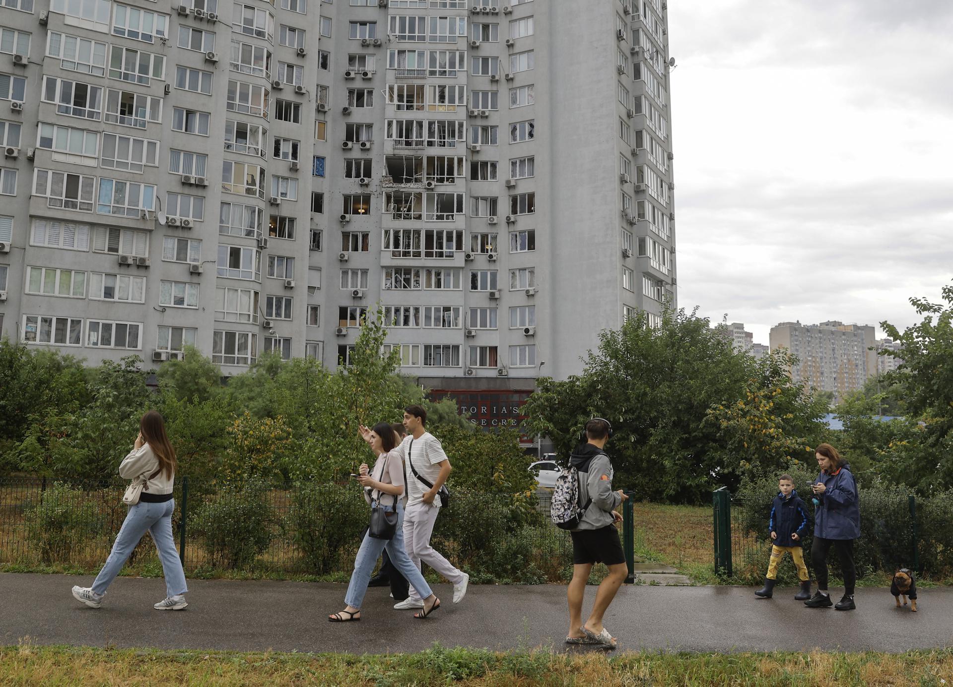 Varias personas pasan junto a un edificio residencial alcanzado por un ataque con drones en Kiev, Ucrania, el 28 de julio de 2025. EFE/EPA/SERGEY DOLZHENKO