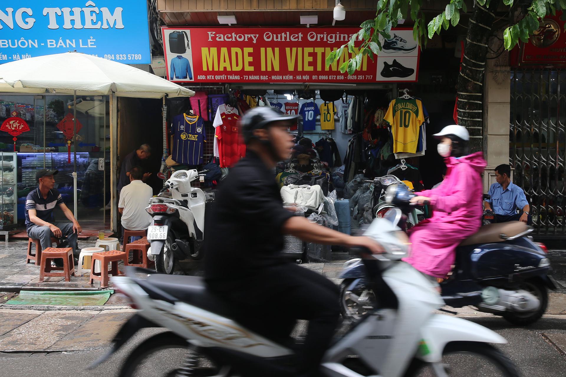 HANÓI (Vietnam), 03/07/2025.- Personas en motocicleta pasan frente a una tienda con rótulo en el que se lee "Hecho en Vietnam" en una calle de Hanói, Vietnam, el 3 de julio de 2025. EFE/EPA/LUONG THAI LINH
