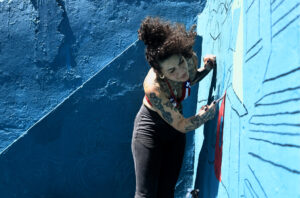La artista Karina 'Kau' Taveras pinta un mural este miércoles, en la Perla en San Juan (Puerto Rico). EFE/ Thais Llorca