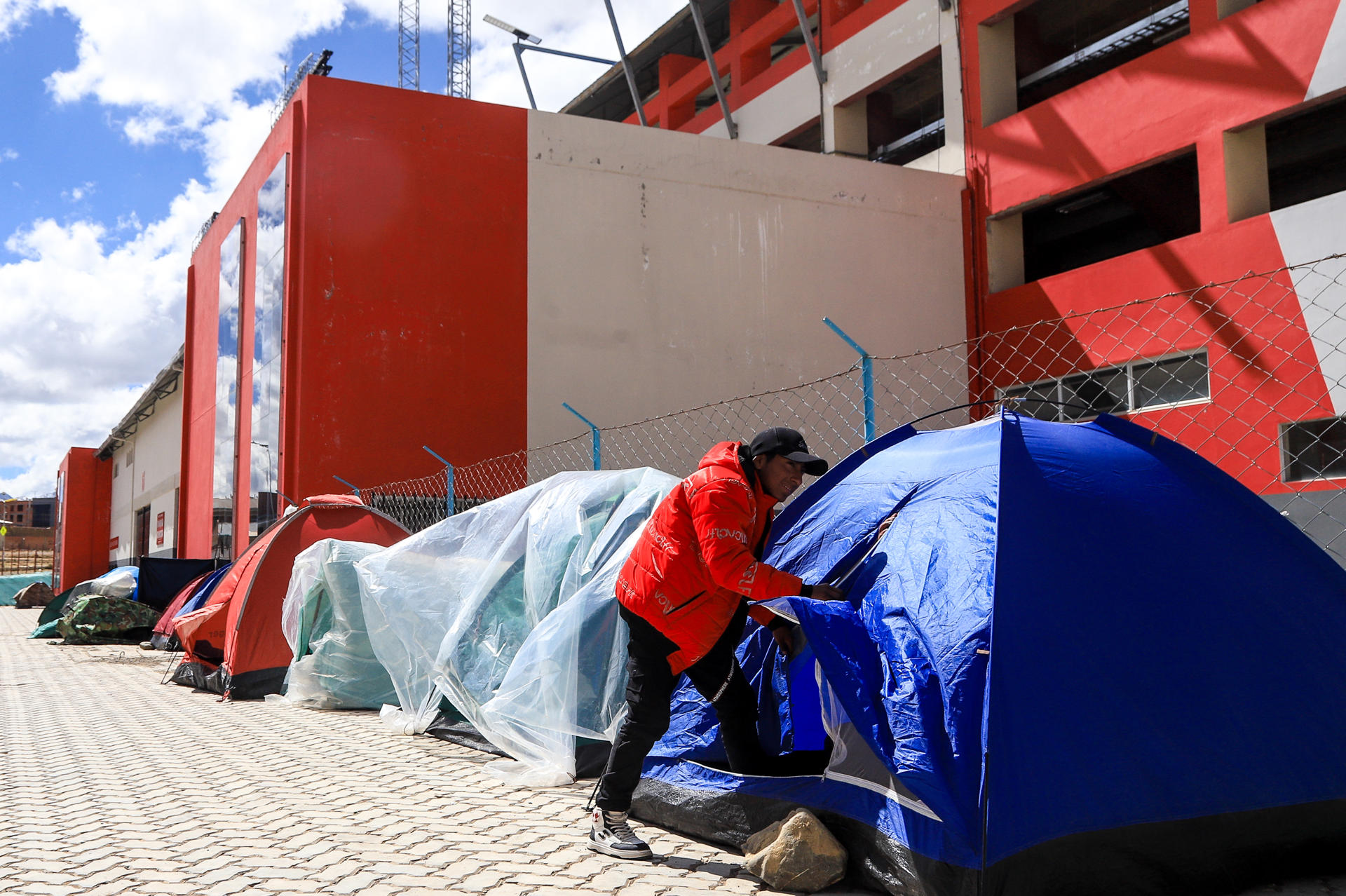 Hinchas bolivianos de fútbol han levantado carpas en los alrededores del estadio Municipal de El Alto con el propósito de evitar las aglomeraciones y a los revendedores que también buscan entradas para asistir al partido de eliminatorias del Mundial con Brasil este 9 de septiembre. EFE/ Gabriel Márquez