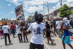 Fotografía de archivo de un hombre participando en una protesta, pidiendo justicia por el asesinato del presidente Jovenel Moïse. EFE/ Johnson Sabin/ARCHIVO