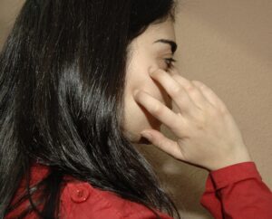 Una joven se rasca la cara a causa de los picores producidos por una dermatitis de contacto. EFE/Paco Torrente