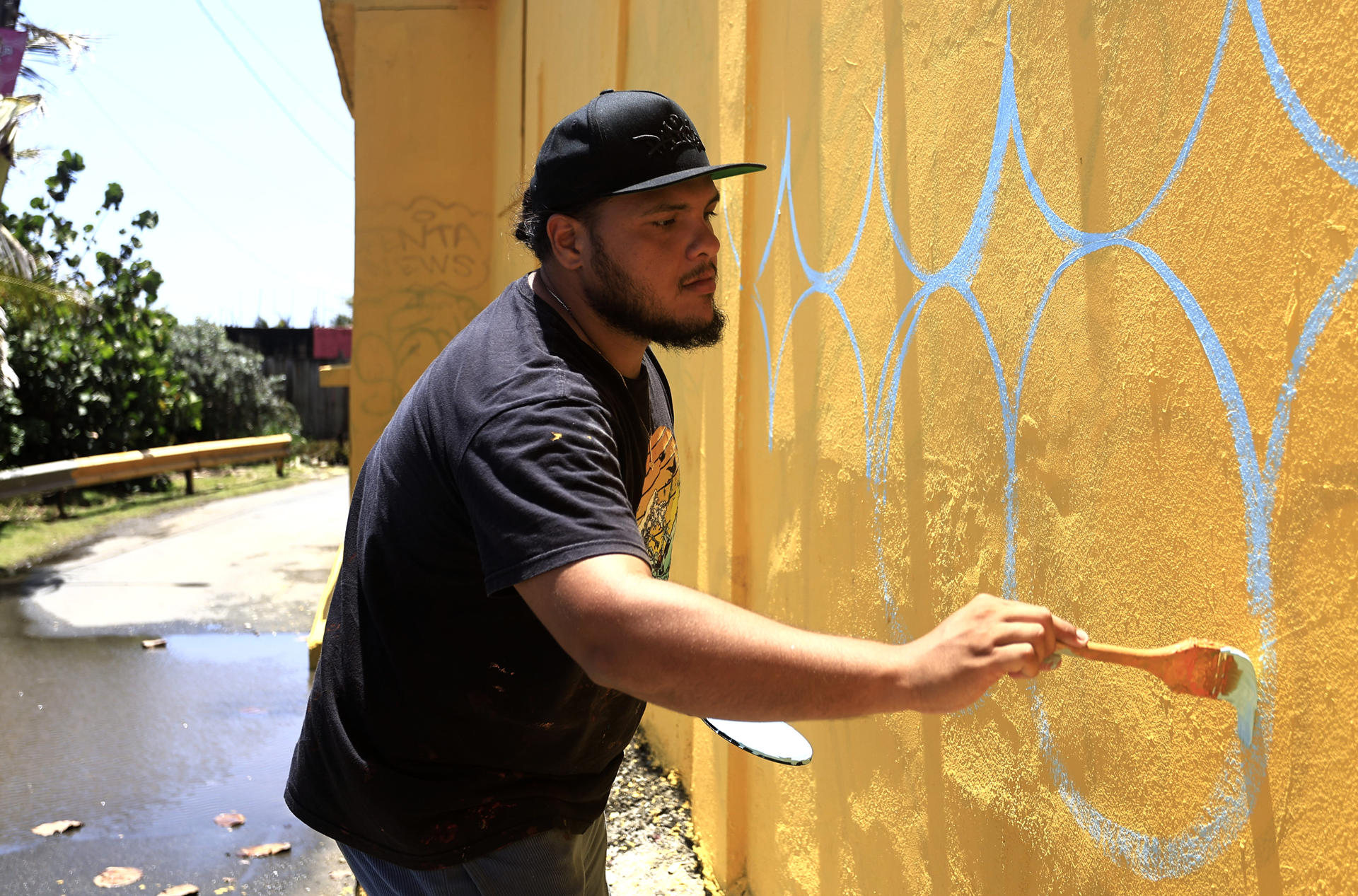 El artista Rafael Enrique 'Rafique' Vega pinta un mural este miércoles, la Perla en San Juan (Puerto Rico). EFE/ Thais Llorca