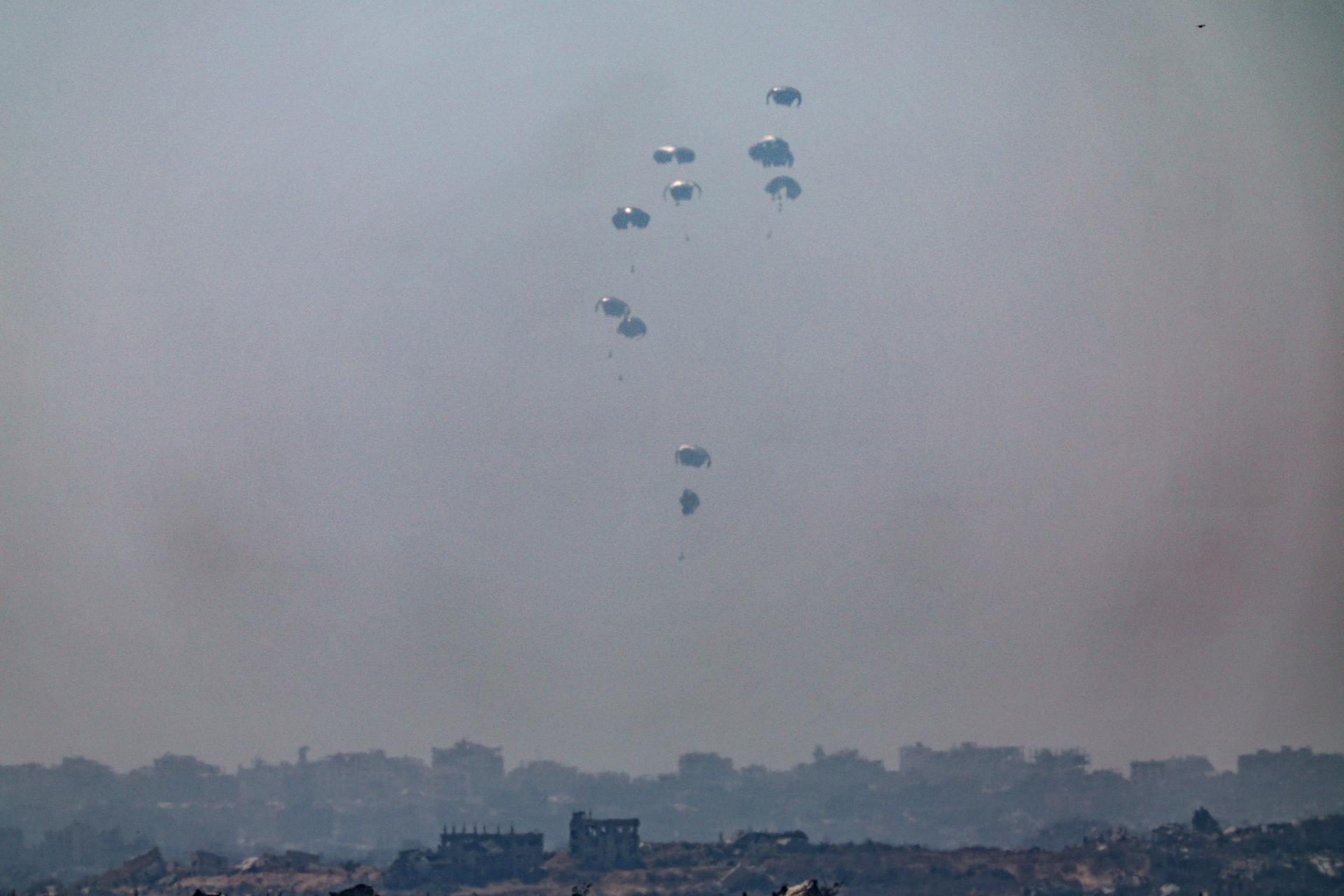 El Ejército jordano lanza ayuda humanitaria en paracaídas sobre la parte norte de la Franja de Gaza, según se ve desde Sderot, en el sur de Israel, este domingo 27 de julio de 2025, para aliviar la crisis humanitaria que ha provocado la muerte por desnutrición de 133 personas en la franja desde el inicio de la guerra. EFE/EPA/ATEF SAFADI