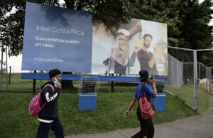 Personas caminan frente a una valla publicitaria de INTEL este jueves, en Belén de Heredia (Costa Rica). EFE/Jeffrey Arguedas
