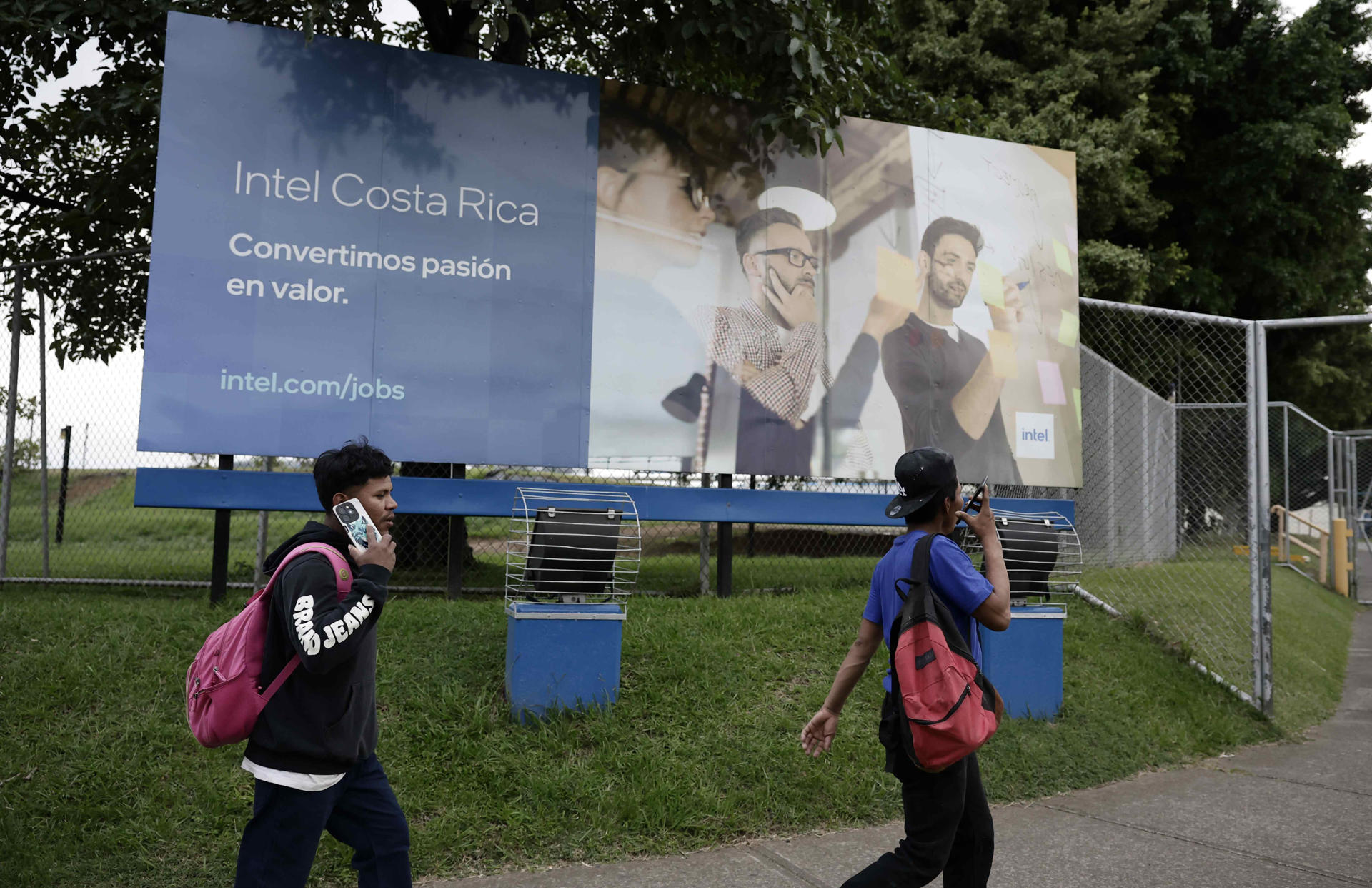 Personas caminan frente a una valla publicitaria de INTEL este jueves, en Belén de Heredia (Costa Rica). EFE/Jeffrey Arguedas