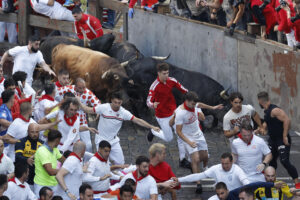 Los mozos son perseguidos por toros de la ganadería gaditana de La Palmosilla durante el séptimo encierro de los Sanfermines 2025 este domingo en Pamplona. EFE/Villar López