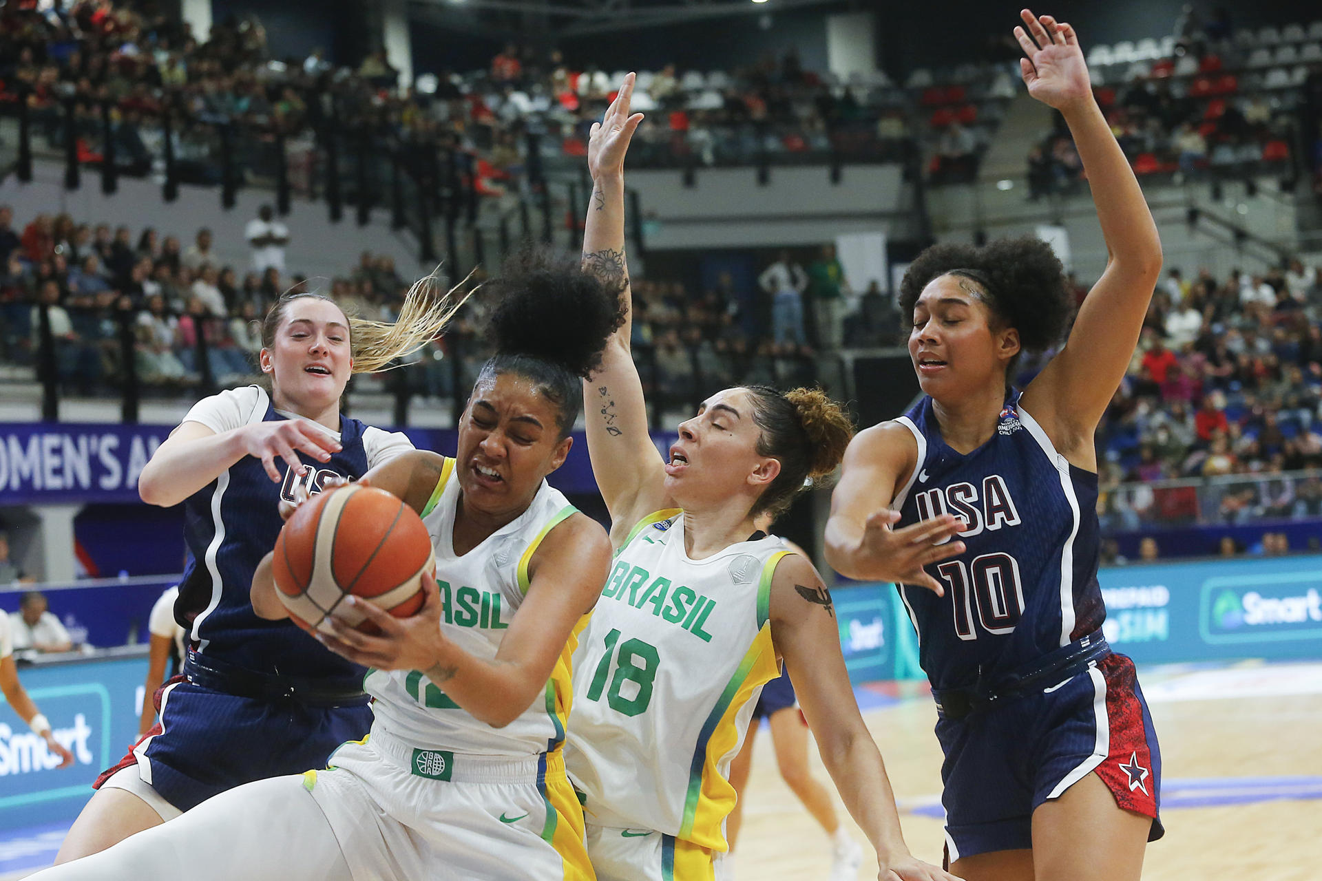 Damiris Dantas (i), de Brasil, disputa un balón con Grace Van Sloote (d), de Estados Unidos, en un partido por la final de la Fiba Women’s Americup entre las selecciones de Brasil y Estados Unidos en el Centro de Deportes Colectivos del Parque Estadio Nacional en Santiago (Chile). EFE/ Esteban Garay