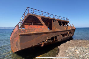 Vista este sábado de un barco, el "SABRI. Ç", que encalló en una playa de la isla griega de Lesbos mientras trasladaba a inmigrantes desde las cercanas costas turcas en 2015, año en el que más de medio millón de refugiados e inmigrantes llegaron a esta isla de unos 80.000 habitantes. EFE/ Diego Sáez Papachristou