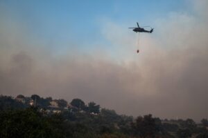 Un helicóptero transporta agua para apagar el fuego durante los incendios forestales en el distrito de Seferihisar este lunes, en de Izmir (Turquía). EFE/EPA/ Murat Kocabas