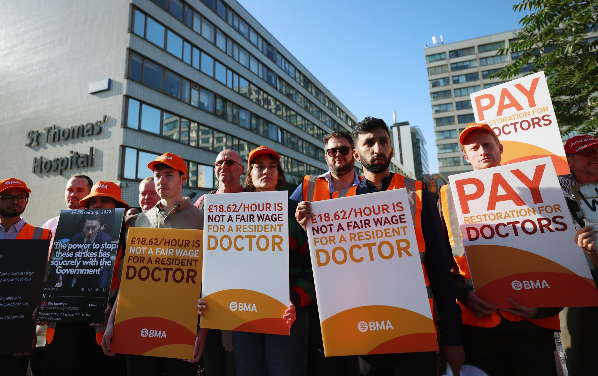 Médicos residentes en huelga sostienen pancartas junto al hospital St. Thomas's en Londres, Reino Unido, el 25 de julio de 2025. EFE/EPA/ANDY RAIN