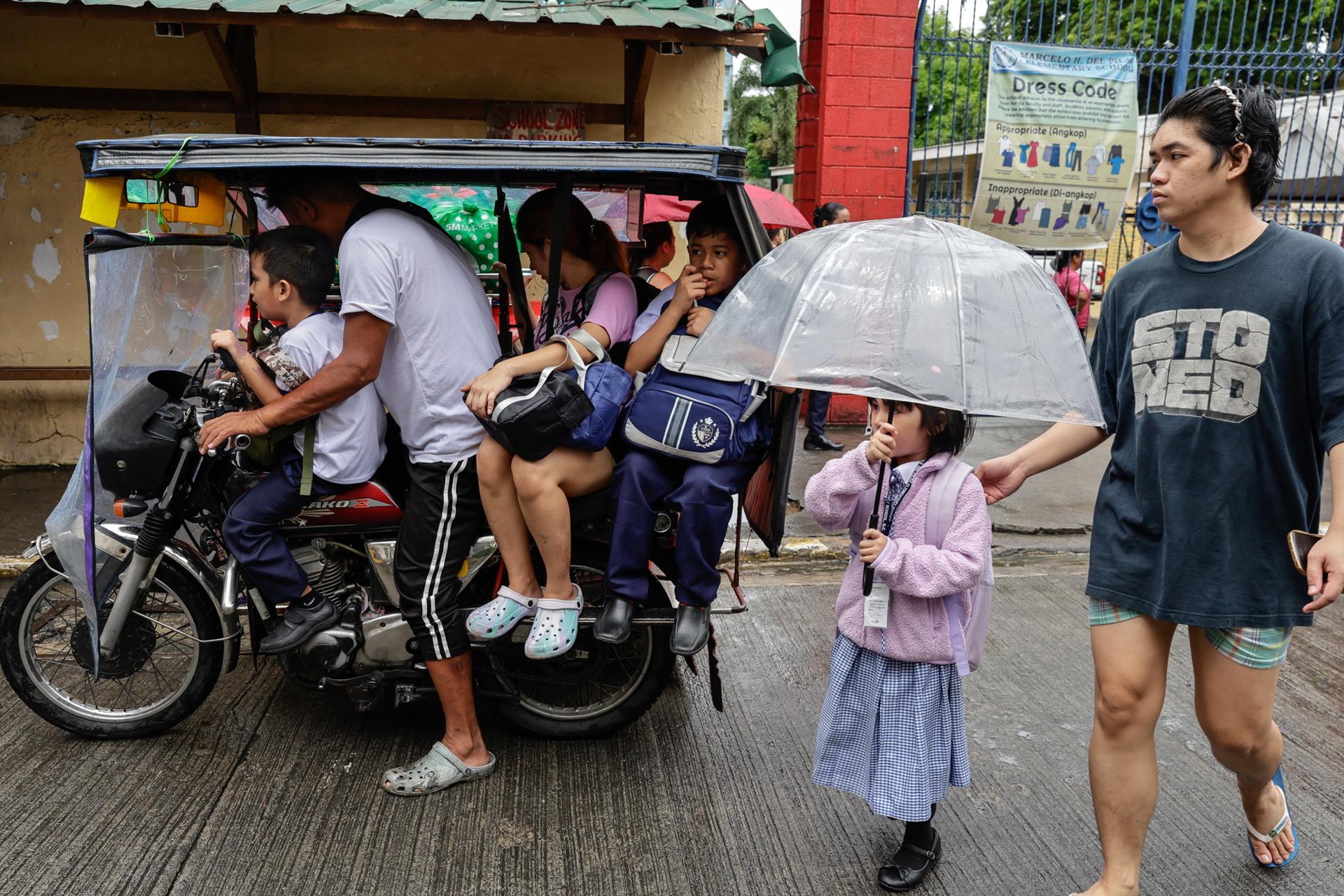 CIUDAD QUEZÓN (Filipinas), 03/07/2025.- Estudiantes con sus padres y tutores salen de una escuela primaria pública tras la suspensión de clases en Ciudad Quezón, Metro Manila, Filipinas, el 3 de julio de 2025, debido a las fuertes lluvias asociadas a la depresión tropical Bising, que se espera produzca inundaciones y deslizamientos de tierra mientras toma fuerza y se desplaza hacia el mar al sur de Taiwán. EFE/EPA/ROLEX DELA PENA