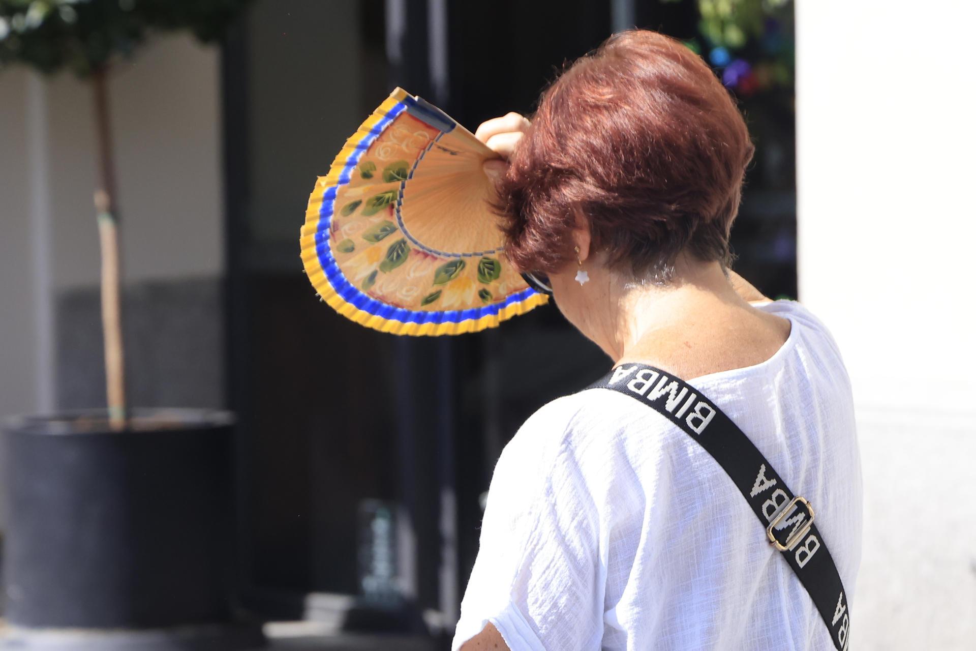 Una mujer se protege del sol con un abanico, este viernes en Madrid. EFE/ Pablo R. Seco