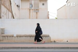 Una mujer camina este lunes por el centro de Torre Pacheco (Murcia), localidad de unos 40.000 habitantes de los que un tercio son inmigrantes de origen magrebí que llevan décadas trabajando sobre todo como peones agrícolas y de almacén. EFE/ Pablo Miranzo