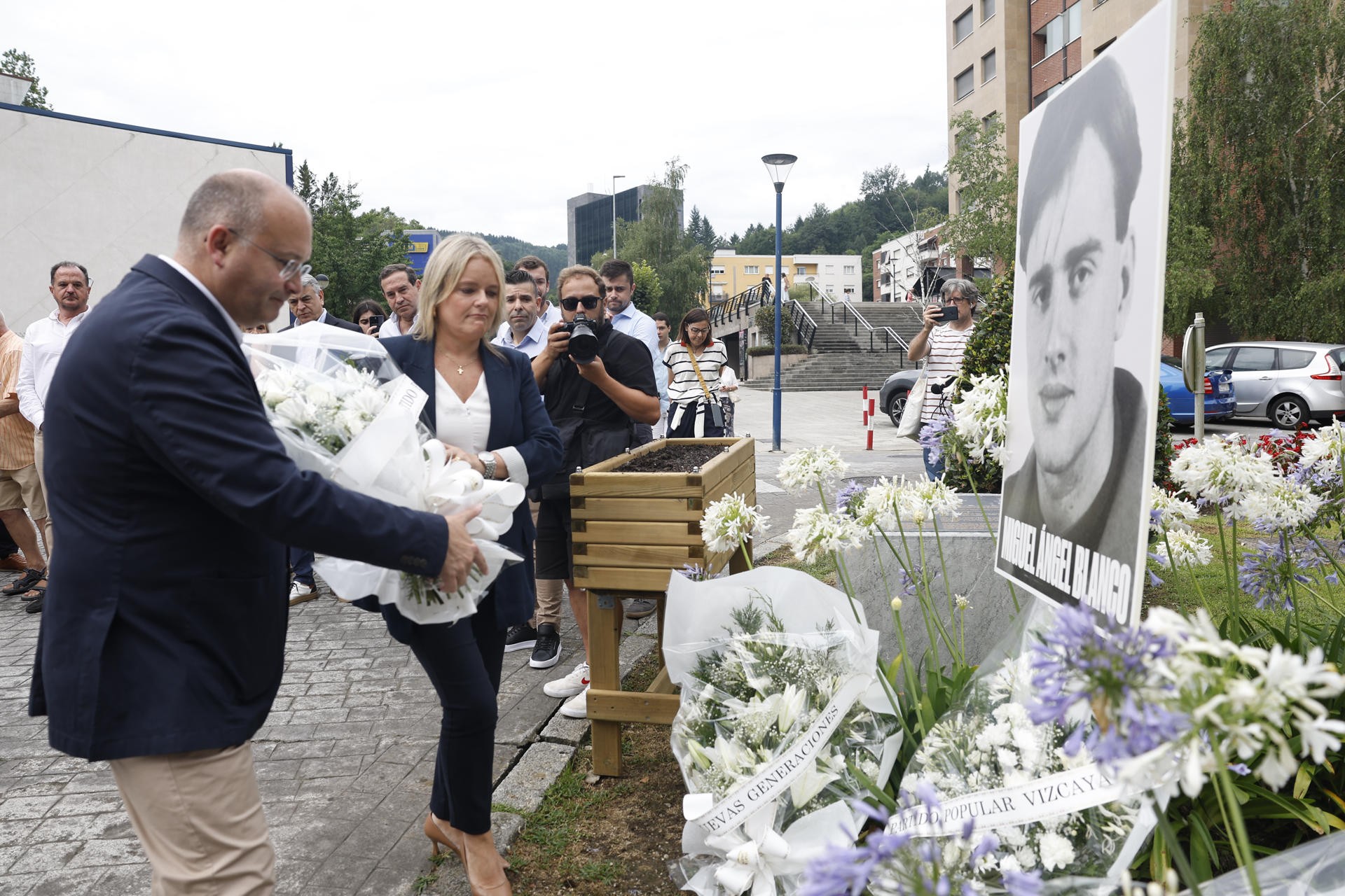 El secretario general del PP, Miguel Tellado (i), junto a Mari Mar Blanco, presidenta de la Fundación Miguel Ángel Blanco (2i), en el acto de recuerdo a Miguel Ángel Blanco con motivo del 28 aniversario de su asesinato por la banda terrorista ETA, este sábado en Ermua (Bizkaia). EFE/Miguel Toña