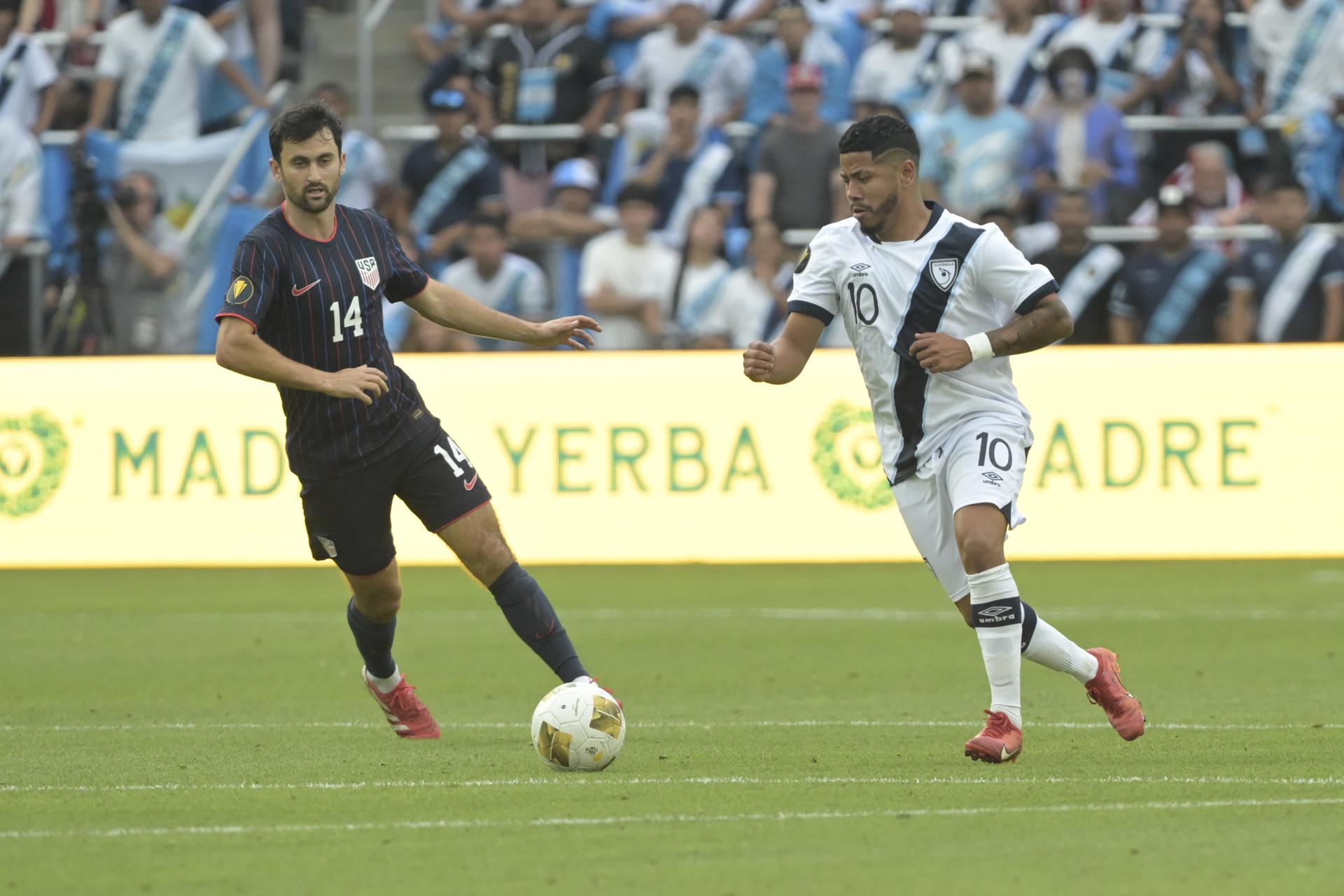 Pedro Altan (d), de Guatemala, conduce el balón ante la mirada de Luca de la Torre, de Estados Unidos. EFE/EPA/MICHAEL THOMAS
