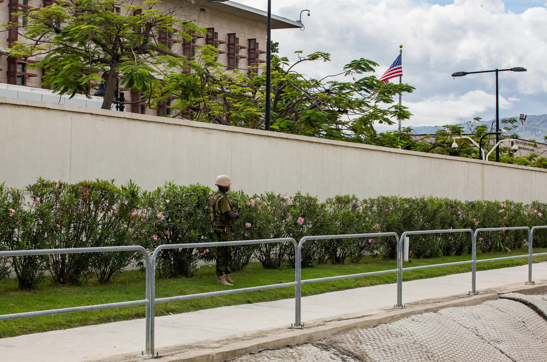 AME9656. PUERTO PRÍNCIPE (HAITÍ), 05/07/2024.- Un policía keniano del primer contingente de la Misión Multinacional de Apoyo a la Seguridad (MMAS) vigila los alrededores de la Embajada de Estados Unidos este viernes, en Puerto Príncipe (Haití). El número de efectivos kenianos debería ser de hasta 2.600 agentes, según el compromiso inicial, pero la misión, que se desplegó con meses de retraso, continúa aún expectante de que otros Estados cumplan con su promesa de envío de personal y/o de recursos financieros. EFE/ Mentor David Lorens